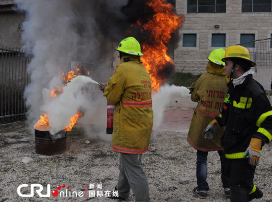 兩名志愿者在消防員的指揮下滅火。（攝影：張瑾） 