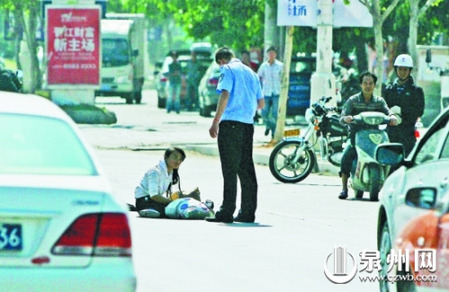 女孩從摩的上摔下，跌坐路中央，恰遇社區(qū)聯(lián)防巡邏人員扶起。