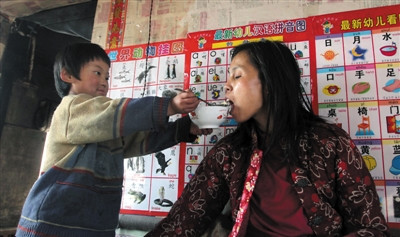 小孫悅為臥床的母親喂飯。